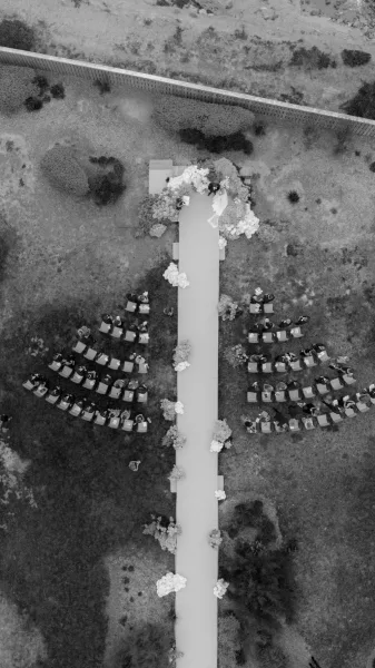 Ceremony setup featuring an outdoor ceremony aisle leading to a wedding arch, arranged for vows under open sky.