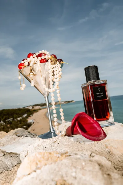 Bridal details with pearl bridal jewelry styled beside a martini glass on a stone ledge, overlooking the beach and ocean.