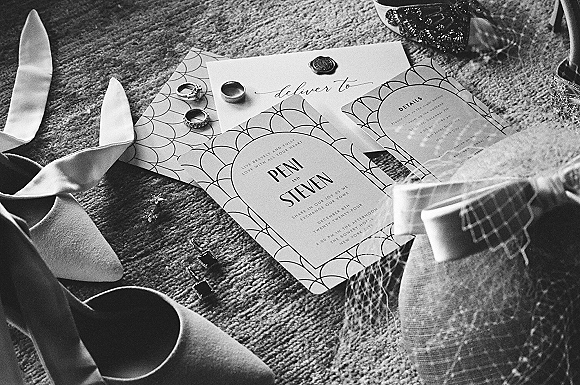 Invitation suite wedding invitation flat lay with envelopes, wax seal, rings, ribbon, bridal heels, veil and hair comb on carpet floor
