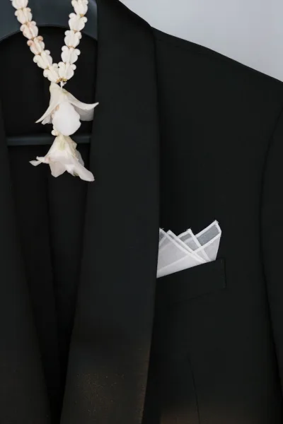 Groom suit with a black suit jacket and crisp white pocket square, showcasing elegant lines and classic groom style for a formal look.