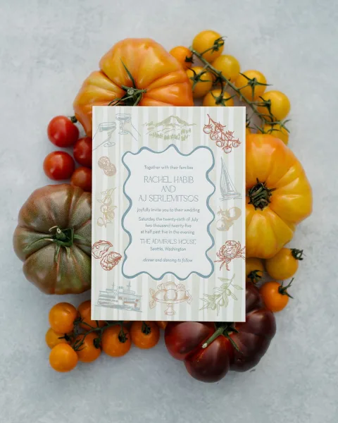 Wedding invitation—an illustrated wedding invitation accented by heirloom tomatoes on a gray stone surface.