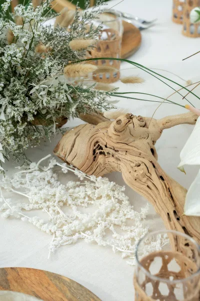 Wedding centerpiece, a dried flower centerpiece built around sculptural driftwood, mixing natural textures for a simple, modern reception table look.