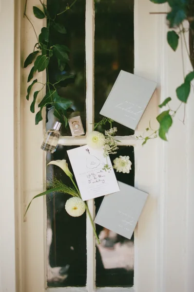 Wedding invitation with vow books arranged by window panes, a refined flatlay highlighting modern calligraphy details