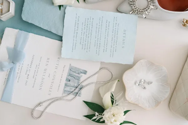 Wedding invitation suite in blue and white stationery styled with a silk ribbon, featuring deckle edges and classic serif typography