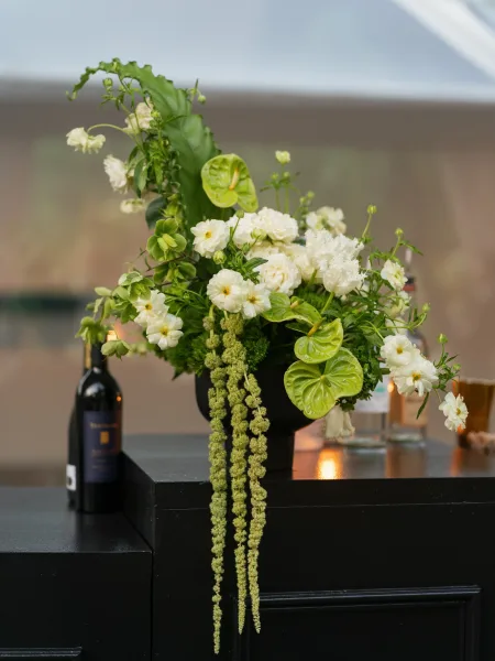 Floral centerpiece, a green and white centerpiece featuring green anthurium on a bar counter against a softly blurred interior.