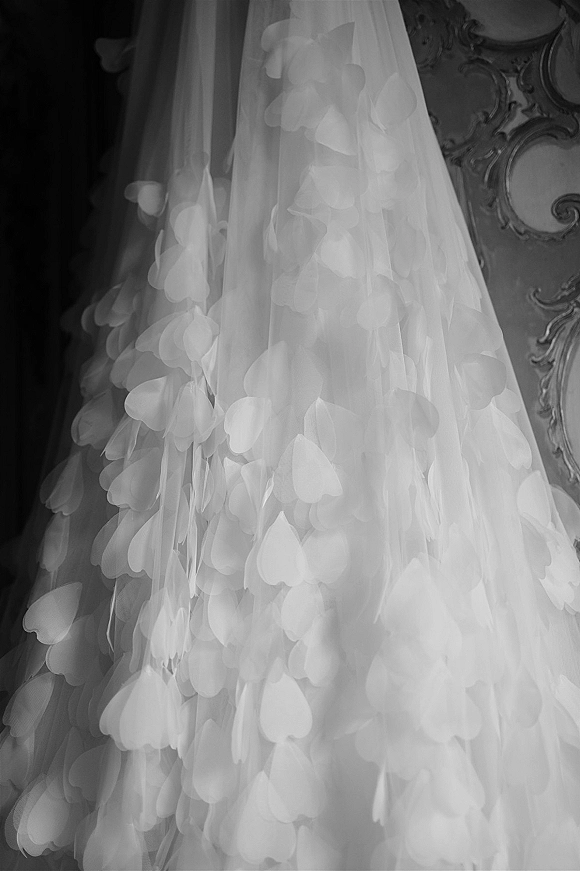 Wedding dress detail with 3D floral wedding dress appliqués and tulle petals, showcased against ornate wall paneling