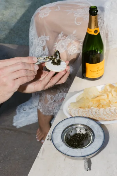 Caviar bar pairing champagne and caviar, set with a mother-of-pearl spoon for guests at a modern wedding cocktail hour.