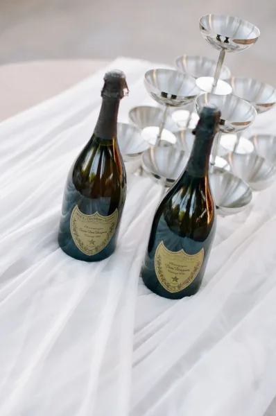 Champagne tower setup features a sparkling wedding champagne tower, flanked by chilled champagne bottles.