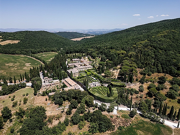 Wedding venue aerial view of a villa wedding venue with stone villa, terracotta roof, formal hedges and cypress driveway amid hills