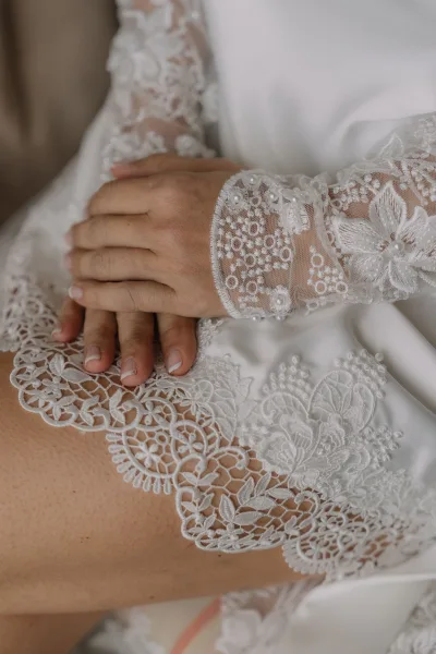 Bridal gown detail showcasing fine stitching and delicate patterns on sheer sleeves, highlighting the graceful texture and craftsmanship