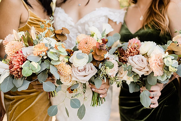 Bridesmaid bouquets with an eucalyptus wedding bouquet mix of roses, dahlias, ranunculus and bunny tail grass against a blurred garden backdrop