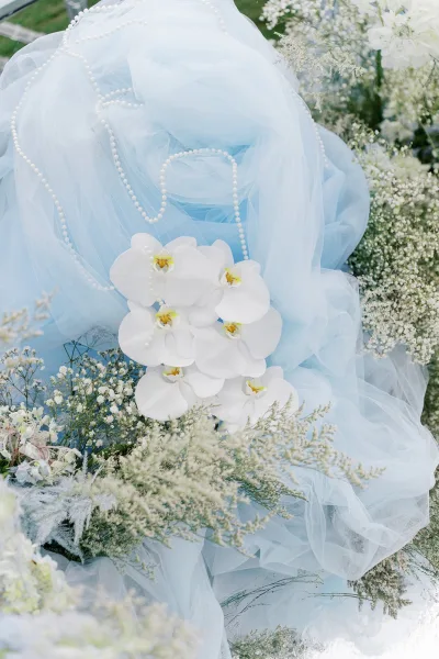 Wedding floral arrangement with blue and white wedding flowers, adorned with orchids and soft, airy textures for an elegant, romantic look.