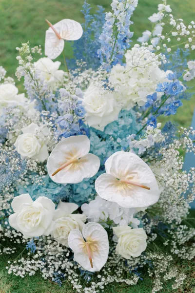 Wedding floral arrangement featuring blue and white wedding flowers with soft blue hydrangea accents in a lush, airy composition.