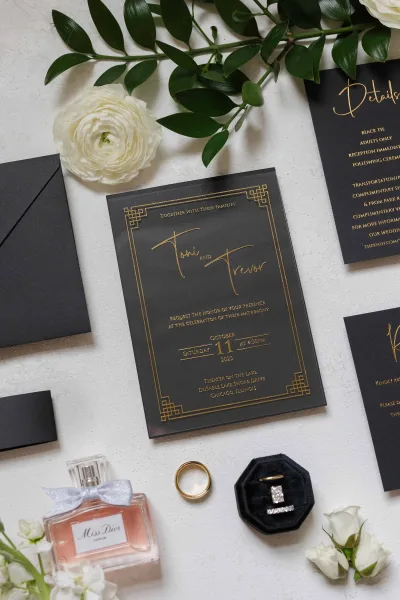 Wedding invitation suite featuring a black and gold invitation, styled with a ring box for a refined, modern look.