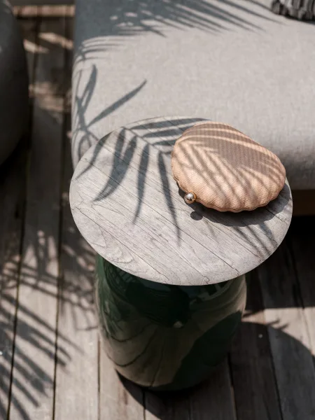 Wedding clutch with shell purse and pearl clasp resting on a wood side table on a sunny deck with palm leaf shadows