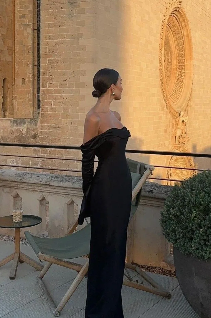 Black off-the-shoulder gown on a stone terrace at golden hour