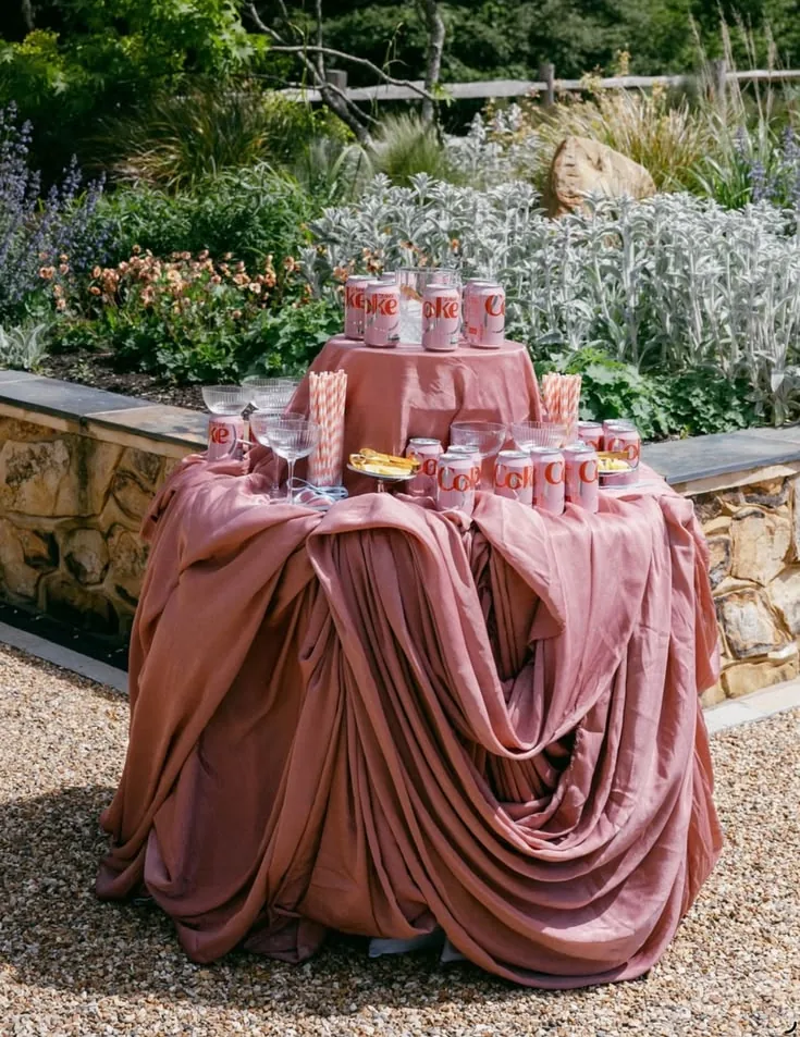 Garden table draped in dusty rose velvet and stacked with pink favors