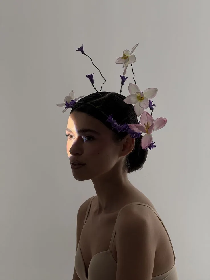 Bride in a strapless bodice wearing a sculptural floral headpiece