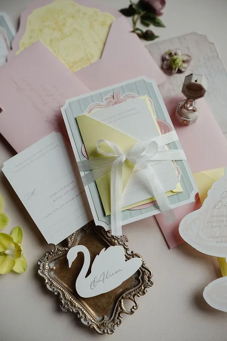 Pink and butter yellow invitation suite with ribbon and a silver swan dish