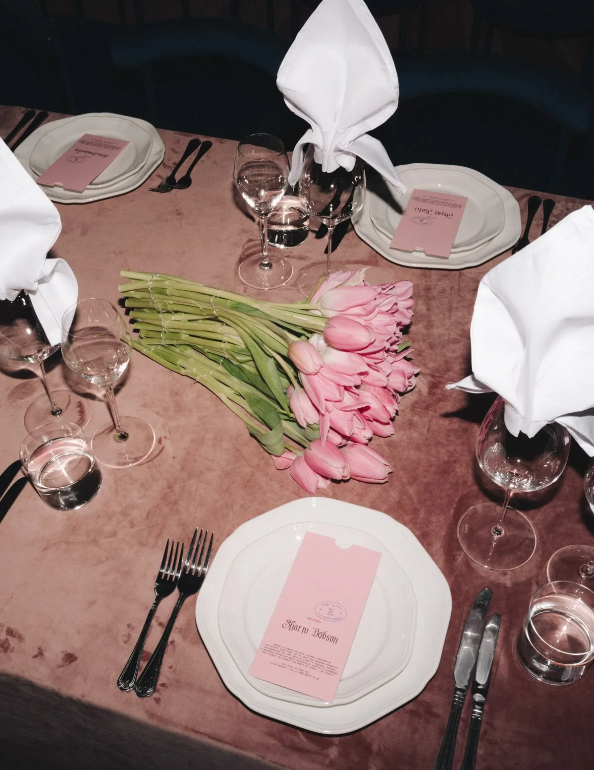 Mauve tablescape with pink tulips, green beans and folded white napkins