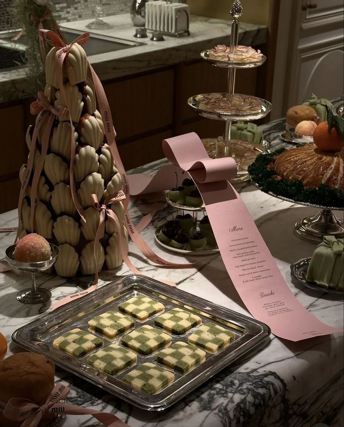Madeleine tower and pink ribbon menu on a marble dessert table