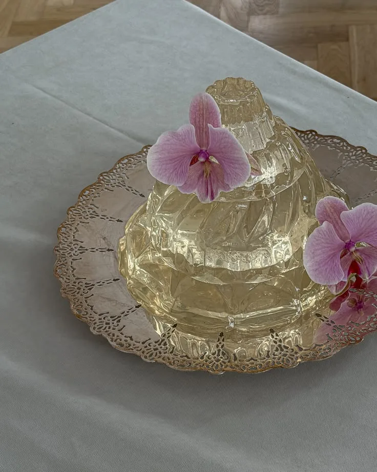 Gilded jelly topped with a pink orchid on a lace doily