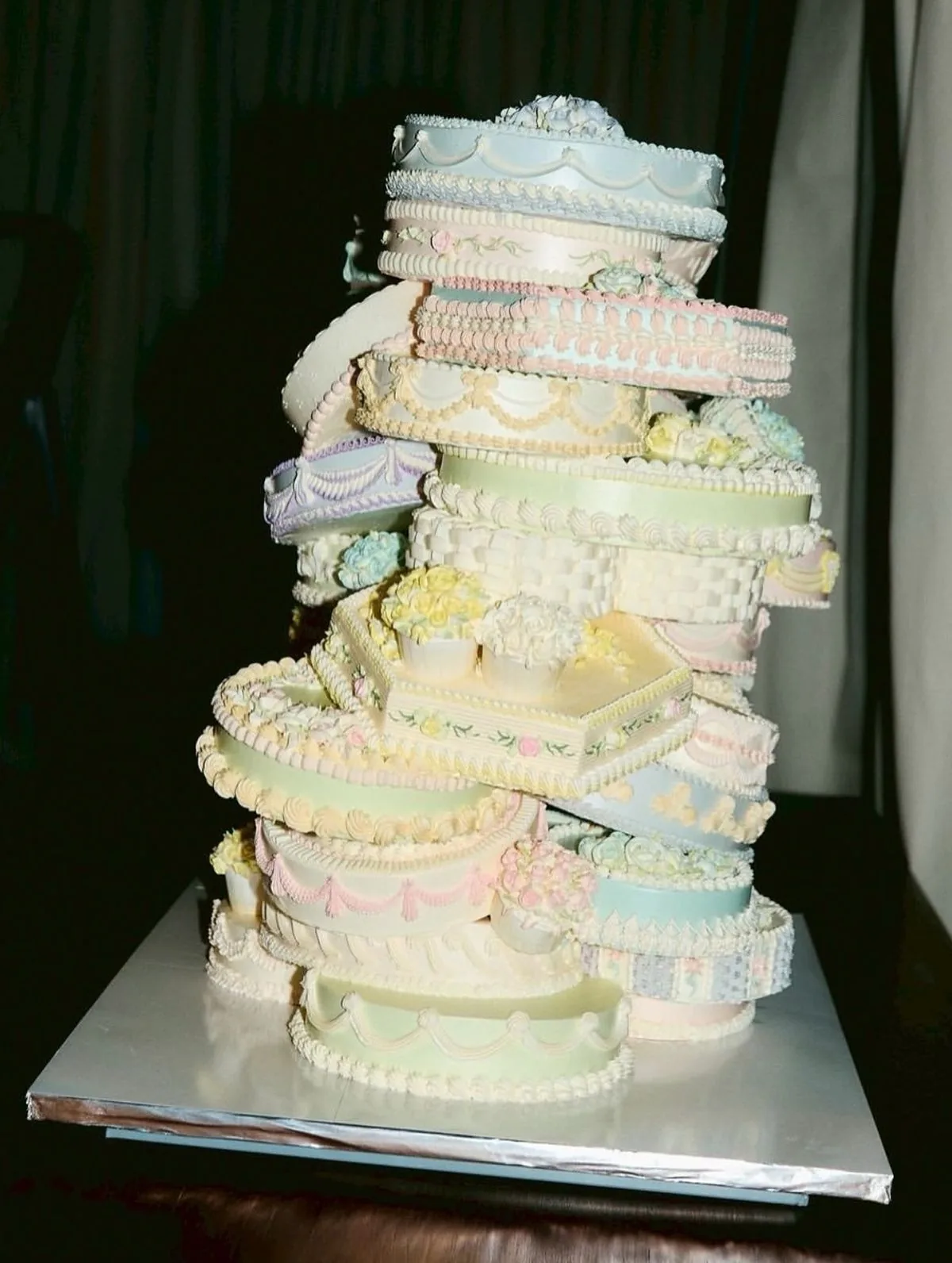 Stacked pastel cake piped with ribbons and sugar flowers