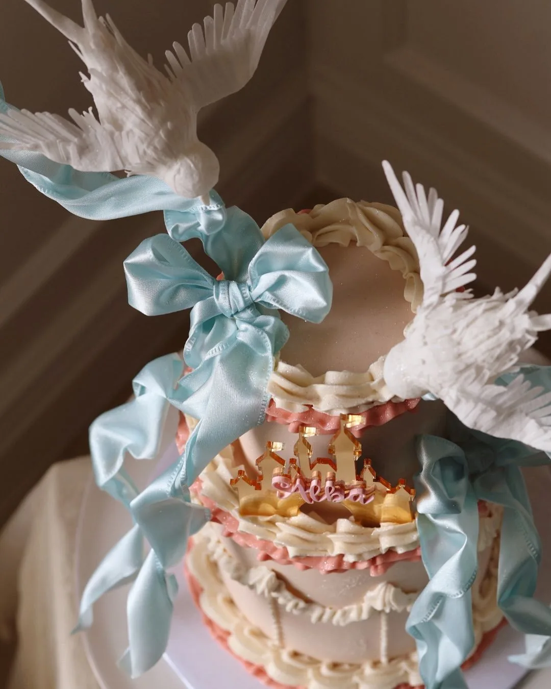 Cake crowned with sugar doves and powder blue ribbons