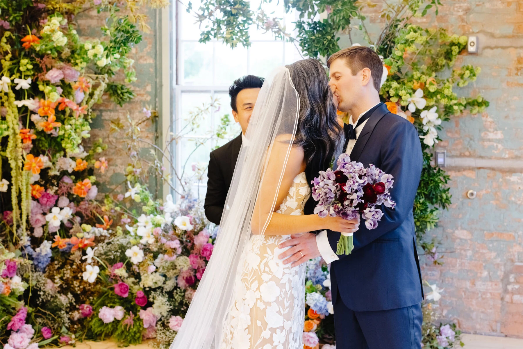 A bride and groom kiss during their art museum wedding ceremony.