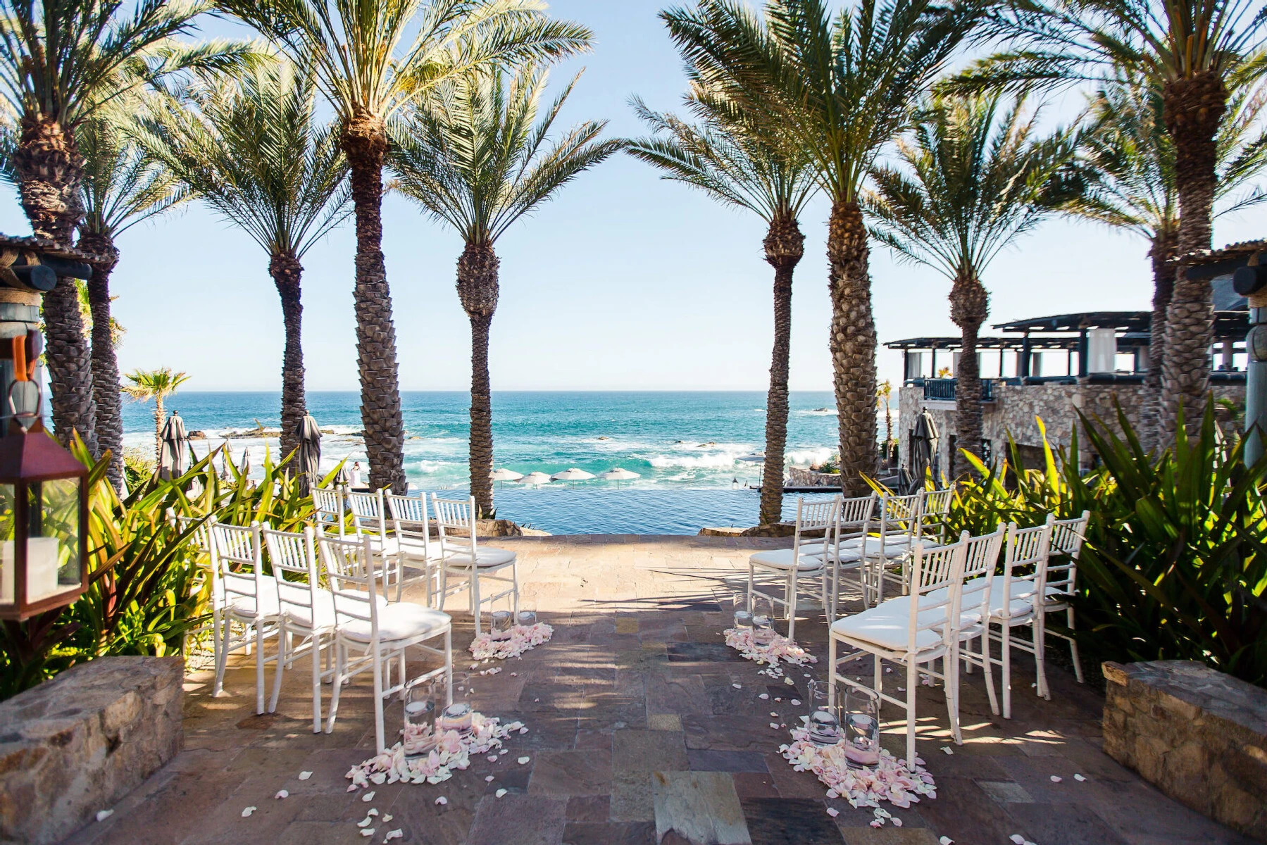 Celebrity Wedding: An outdoor ceremony setup with palm trees and the ocean in the background in Mexico.