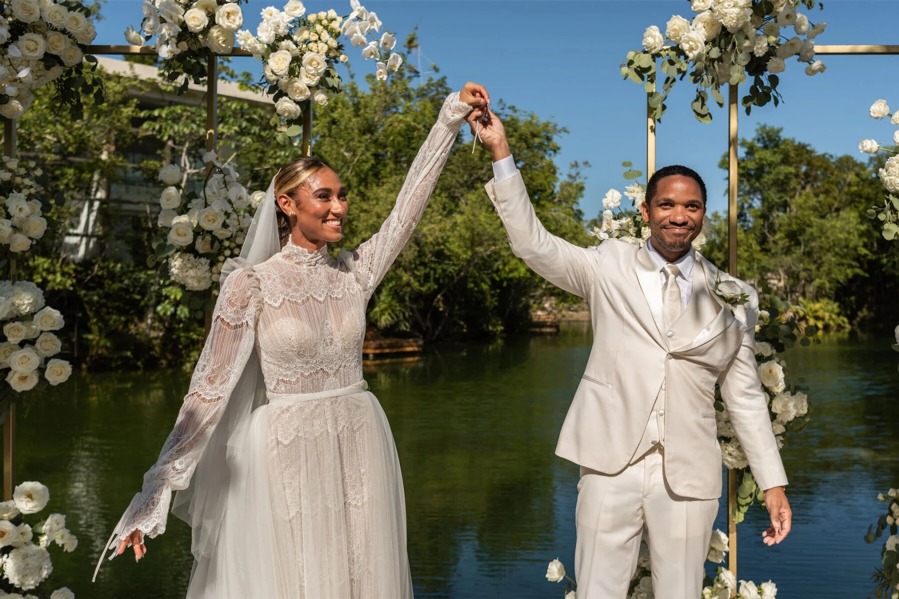 Celebrity Wedding: Peloton instructor Ally Love holding hands with her husband Andrew at their wedding ceremony, overlooking the water, in Mexico.