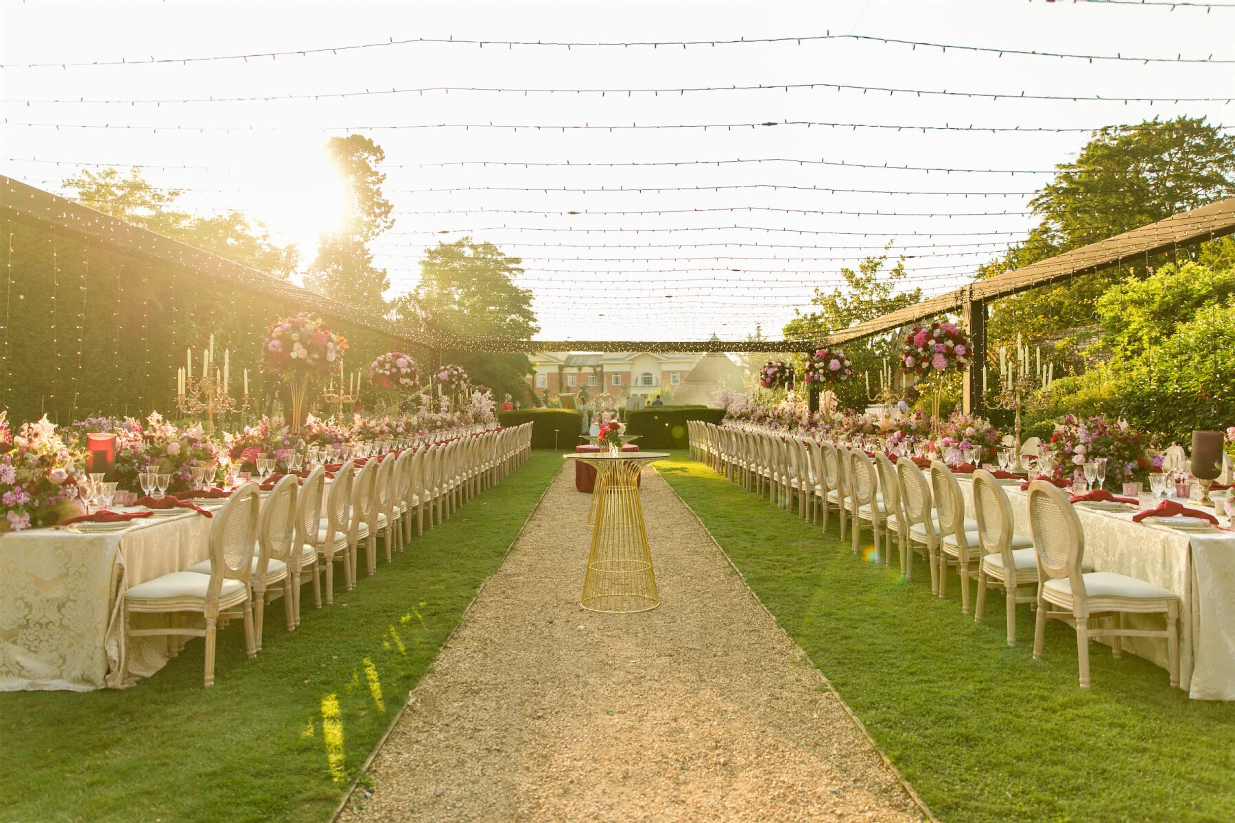 Two long tables set under string lights in the garden, were a romantic setting for a colorful countryside wedding.