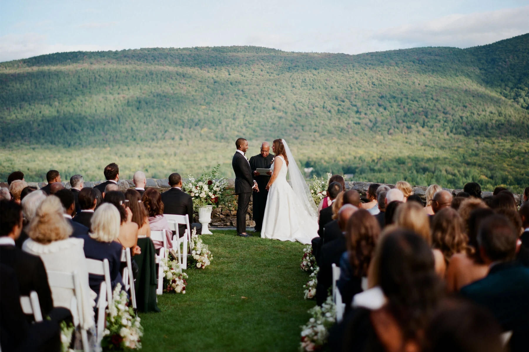 An elevated garden wedding ceremony with the mountains of Vermont in the background.