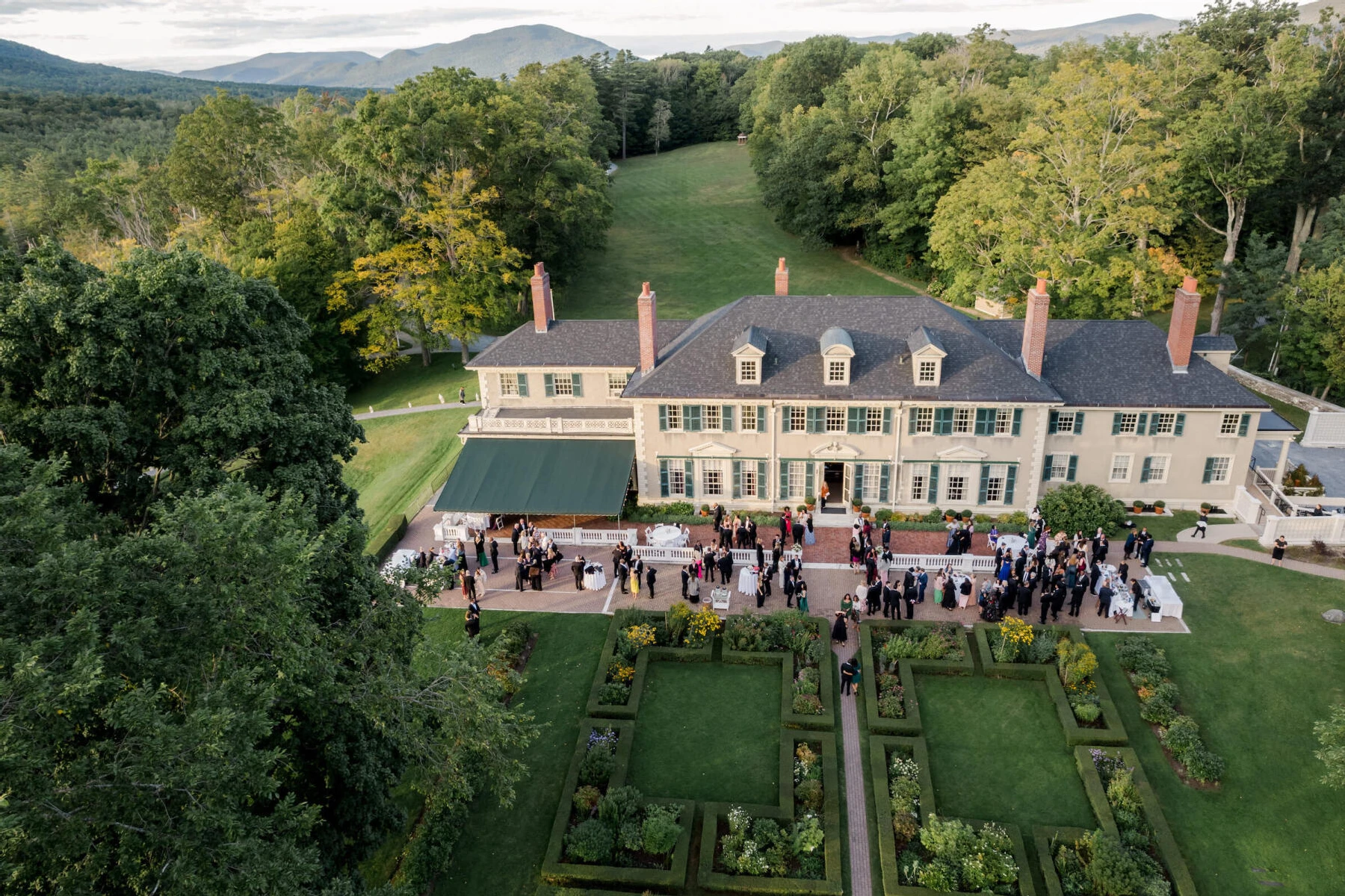 An overhead photograph of an elevated garden wedding's cocktail hour on the grounds of Hildene, in Vermont.