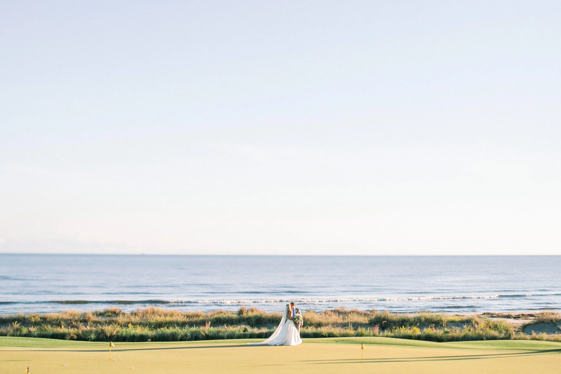 Golf Course Wedding Venues: A wedding couple on an oceanfront golf course in Kiawah Island, South Carolina.