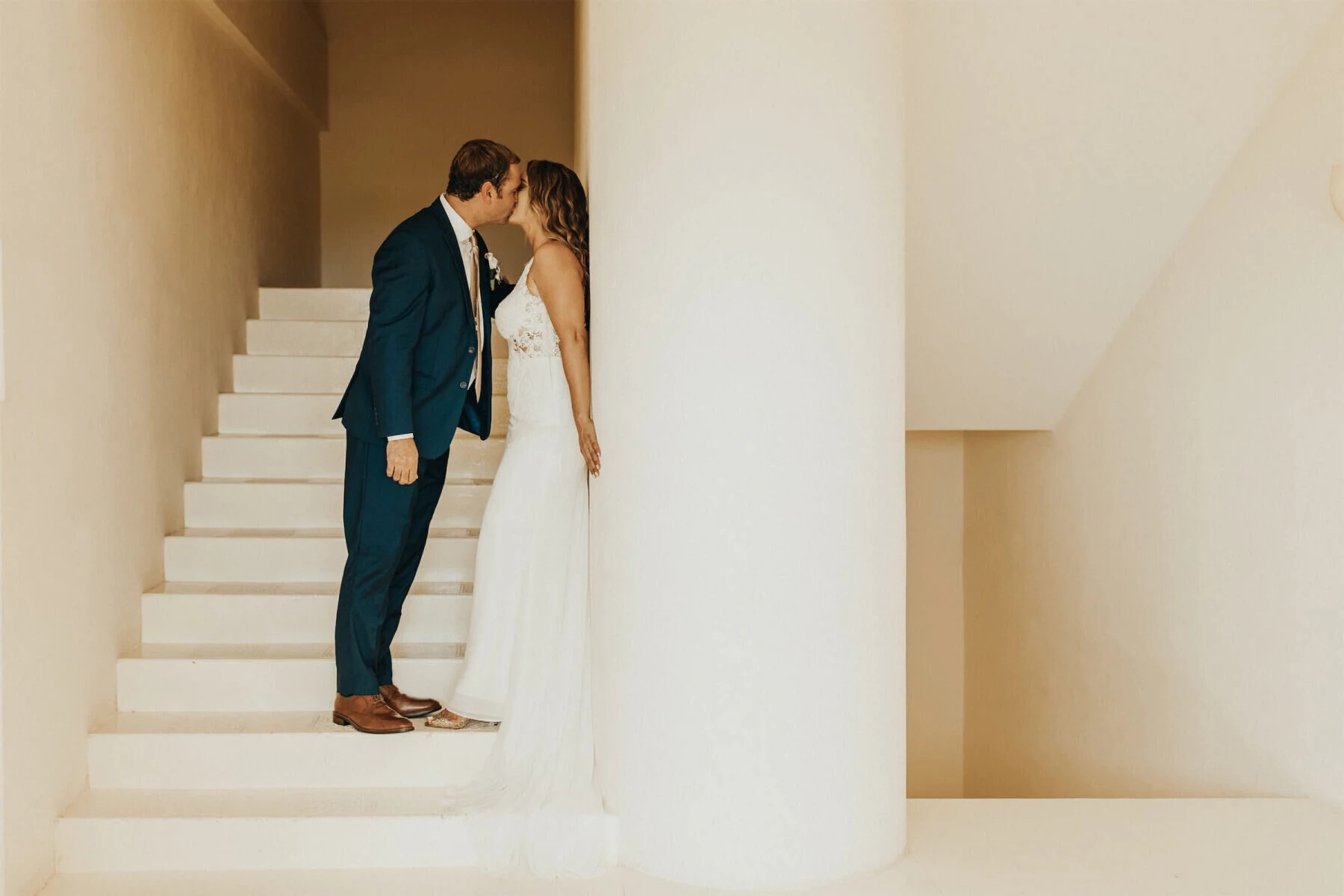 Grand Velas Riviera Nayarit: A couple sharing a kiss in the middle of a tall white staircase.