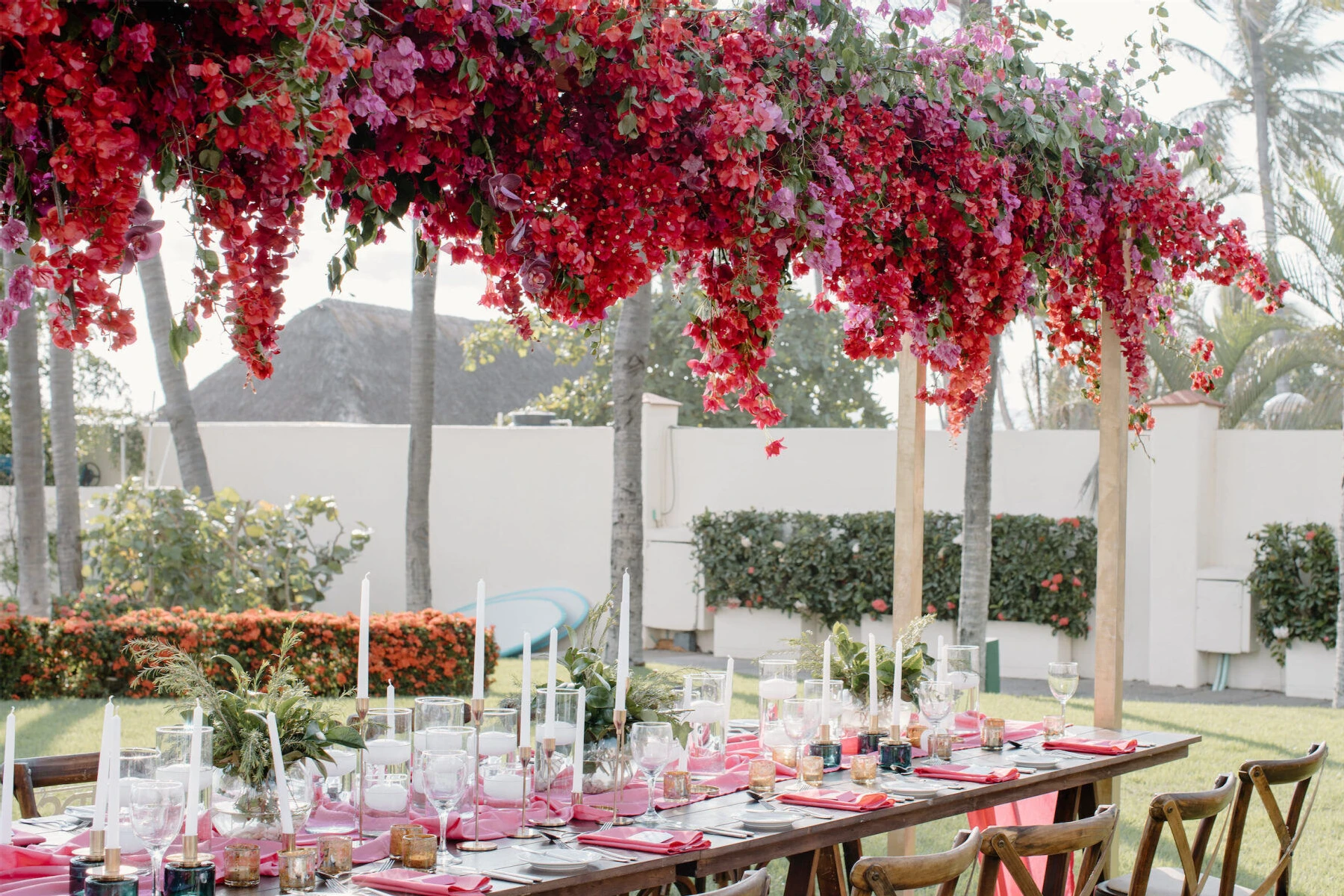 Grand Velas Riviera Nayarit: Suspended red and pink flowers hanging over an elaborate tablescape at a wedding reception.