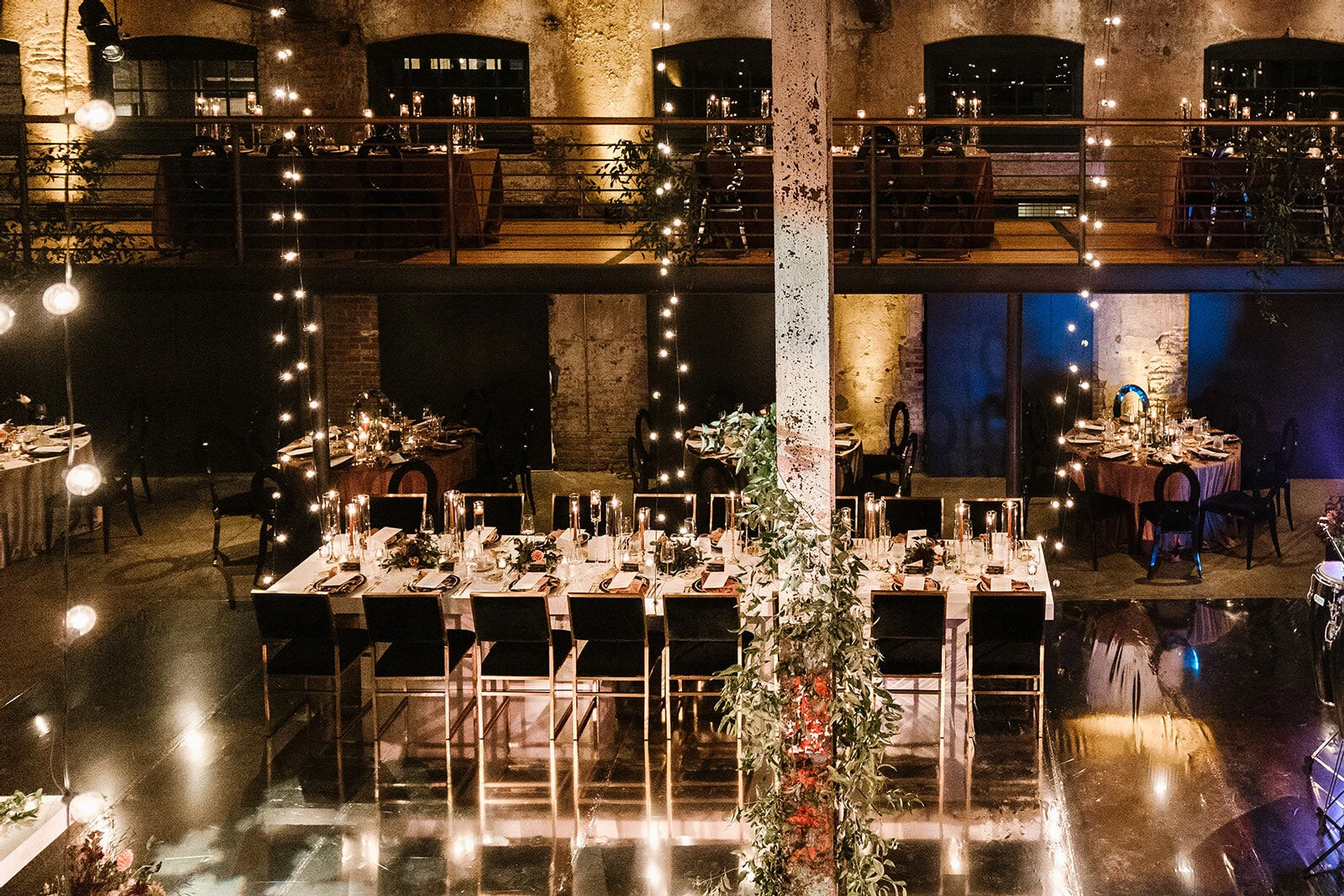 Flower installations and strands of bistro bulbs customized and softened the raw event space at this industrial wedding.