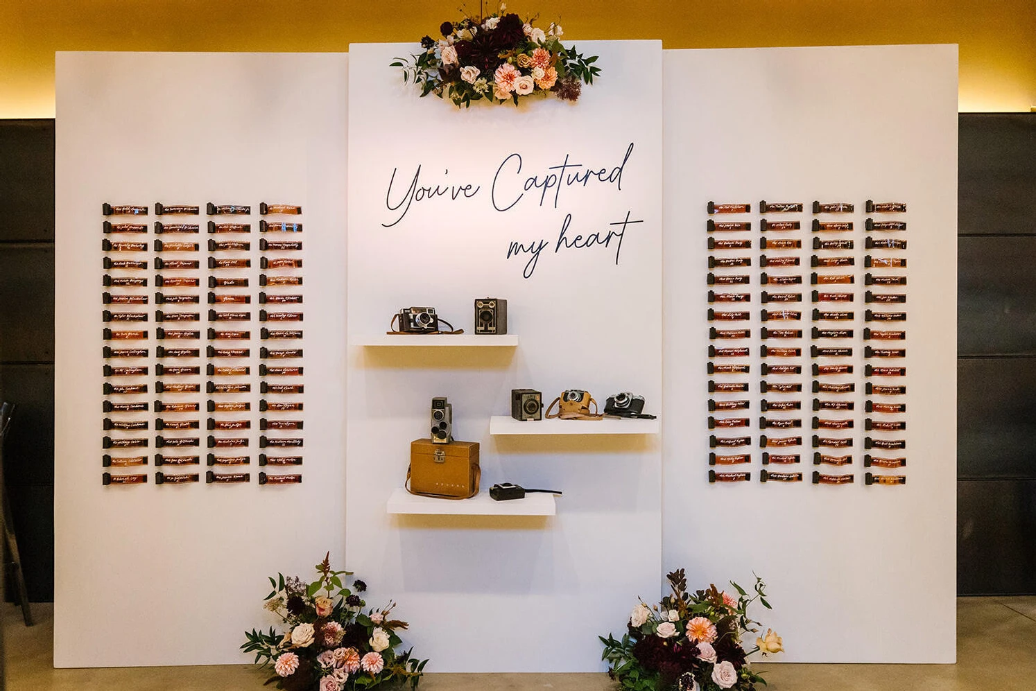 An escort card installation incorporated calligraphed film canisters and vintage cameras. It was just one way the couple personalized their industrial wedding.