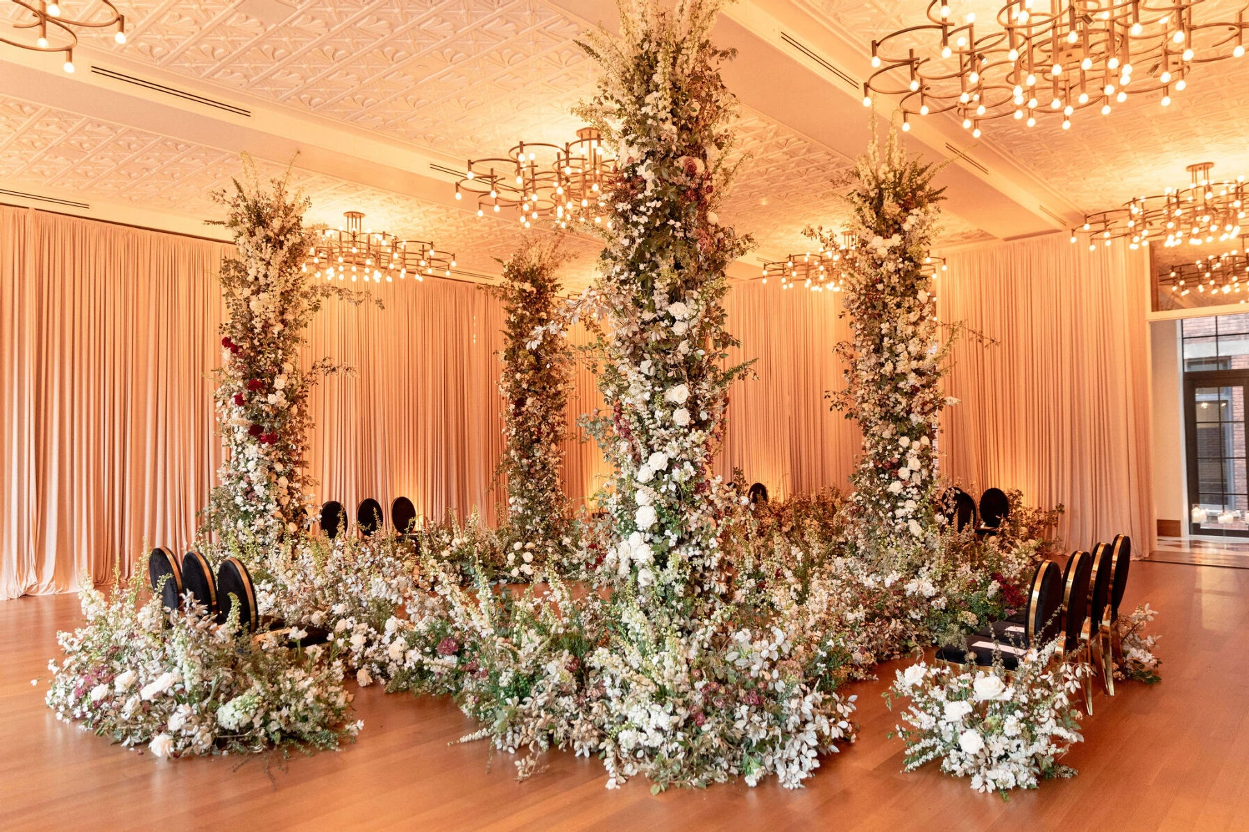 An event space at the Shinola Hotel was draped along the perimeter and set for a ceremony-in-the-round with four large floral columns.