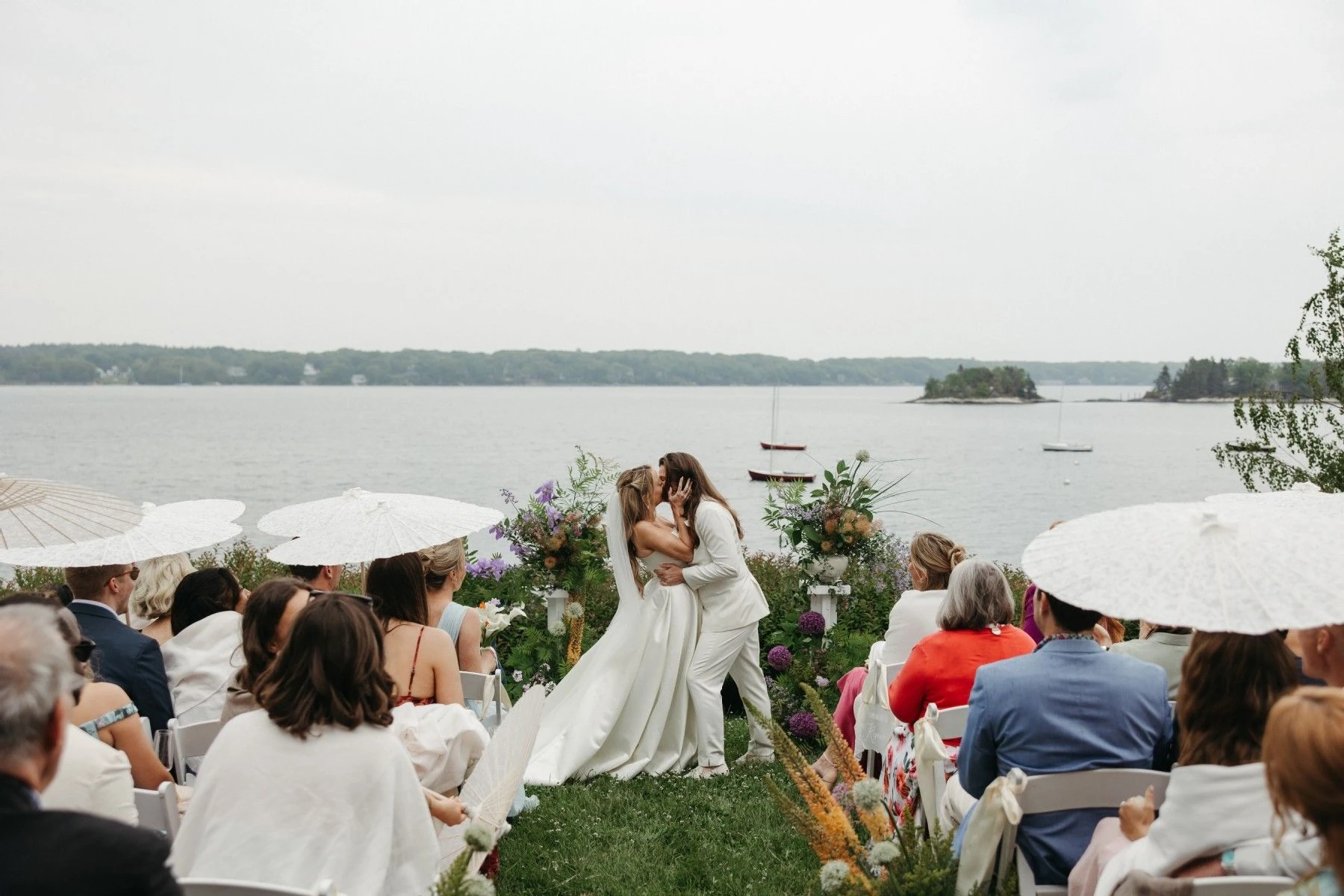 A wedding couple kissing at a waterfront ceremony at Linekin Bay Resort in Boothbay Harbor, Maine, photographed by Magic Arrow Photography