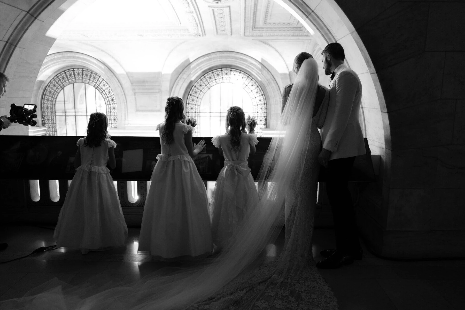 Kate Bock Kevin Love Wedding: Kate Bock and Kevin Love looking over a balcony with their flower girls after their wedding ceremony at The New York Public Library.