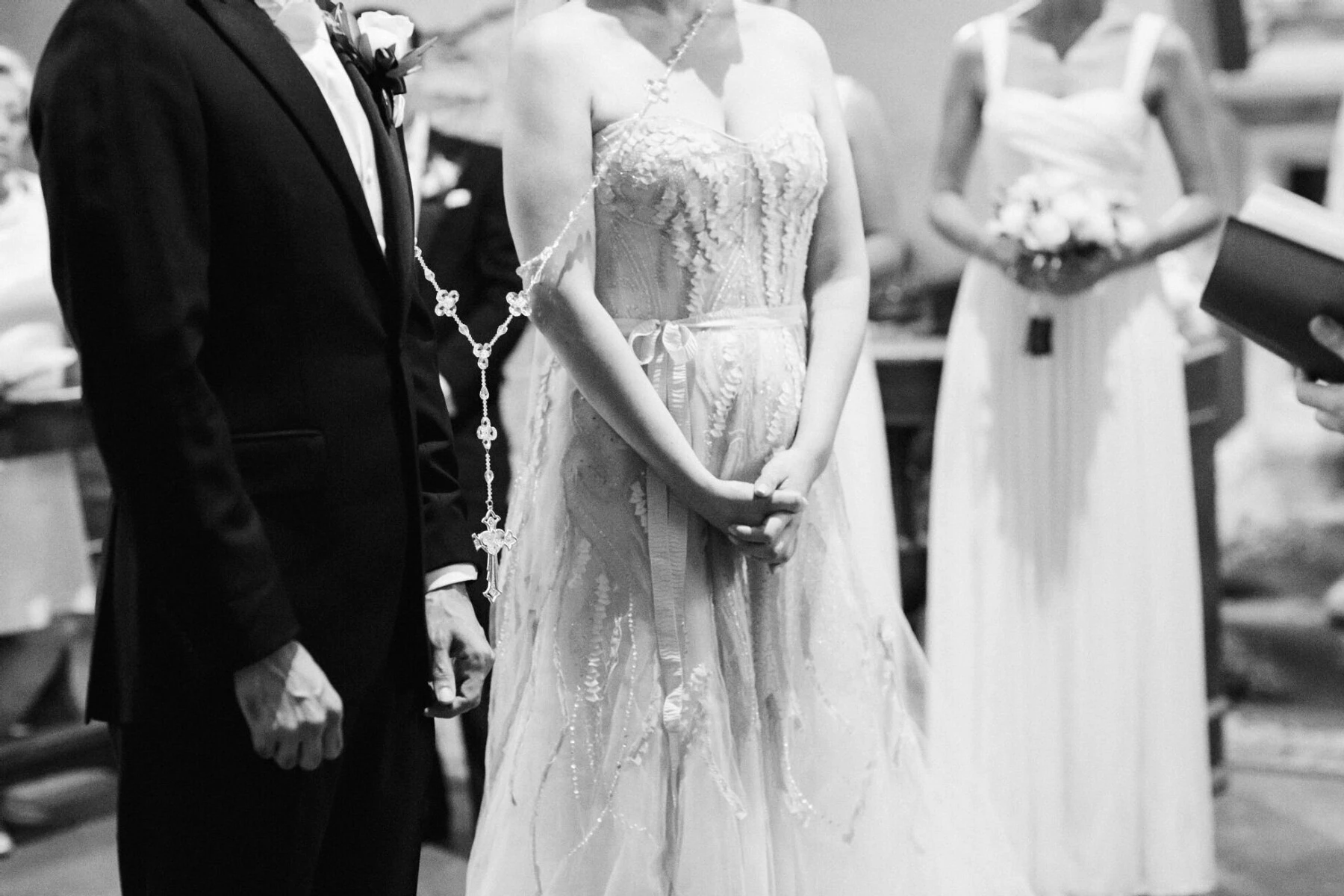 Latinx Heritage: A below-the-shoulders view of a bride and groom with a lasso adorned with a cross.