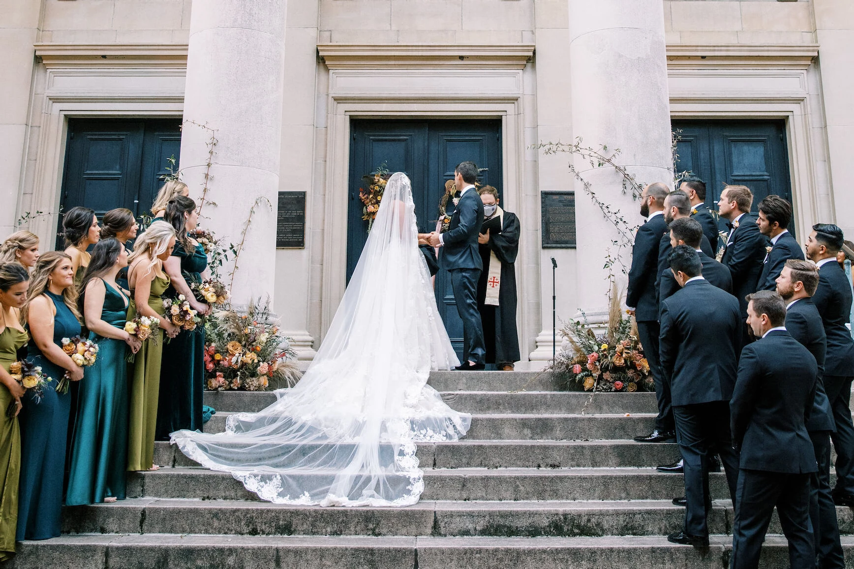 Latinx Heritage: A bride and groom getting married on the steps of a church with their wedding party looking on.