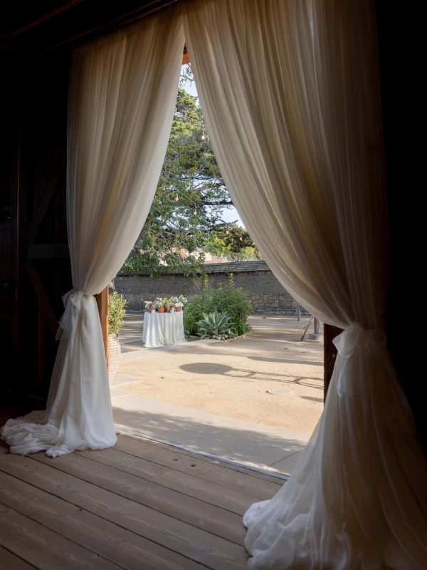 A Burgundy and Green Wedding Draped Between Old Plaster and Weathered Wood