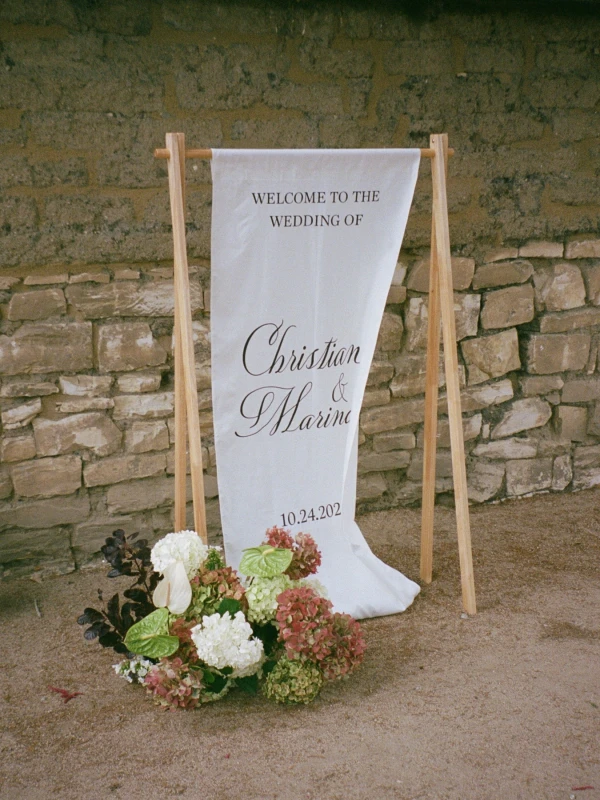 A Burgundy and Green Wedding Draped Between Old Plaster and Weathered Wood