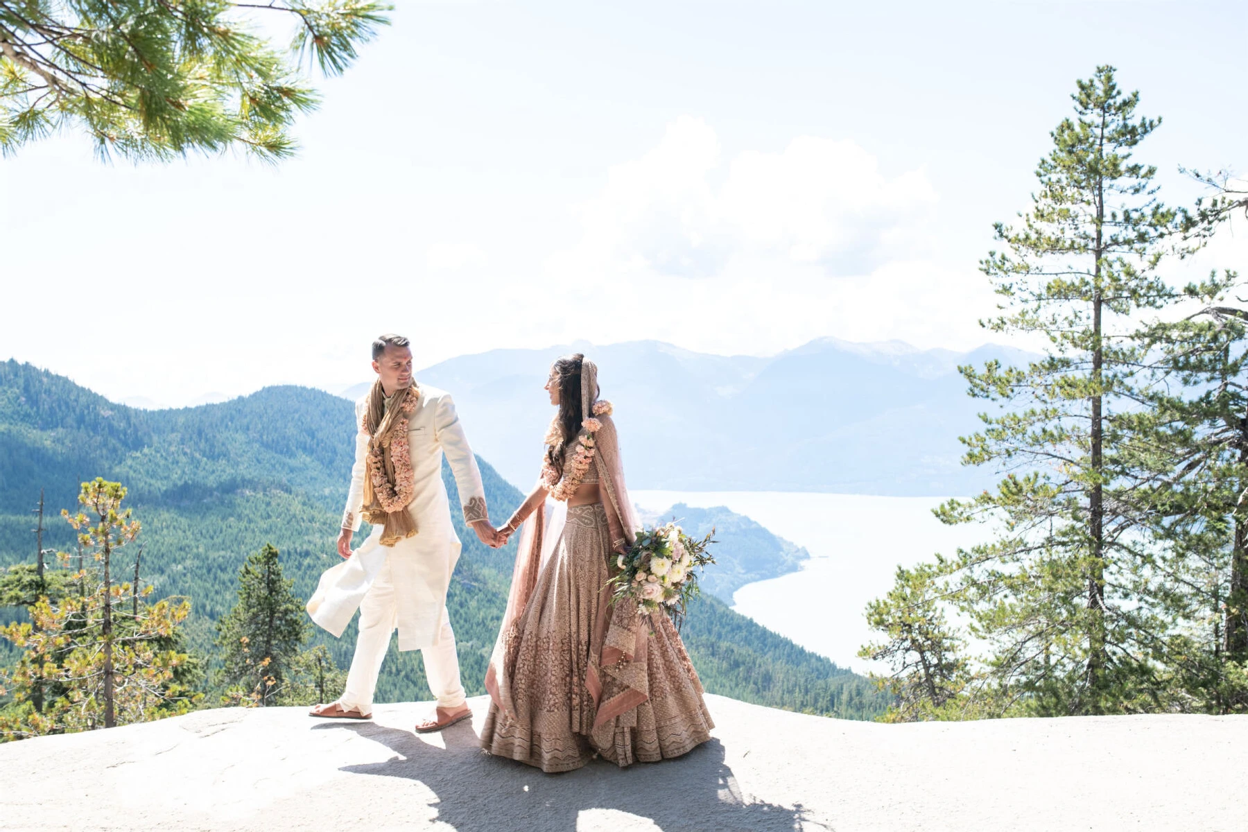 Marriott Weddings: A wedding couple holding hands and walking on a ledge near a bay in Vancouver, Canada.  