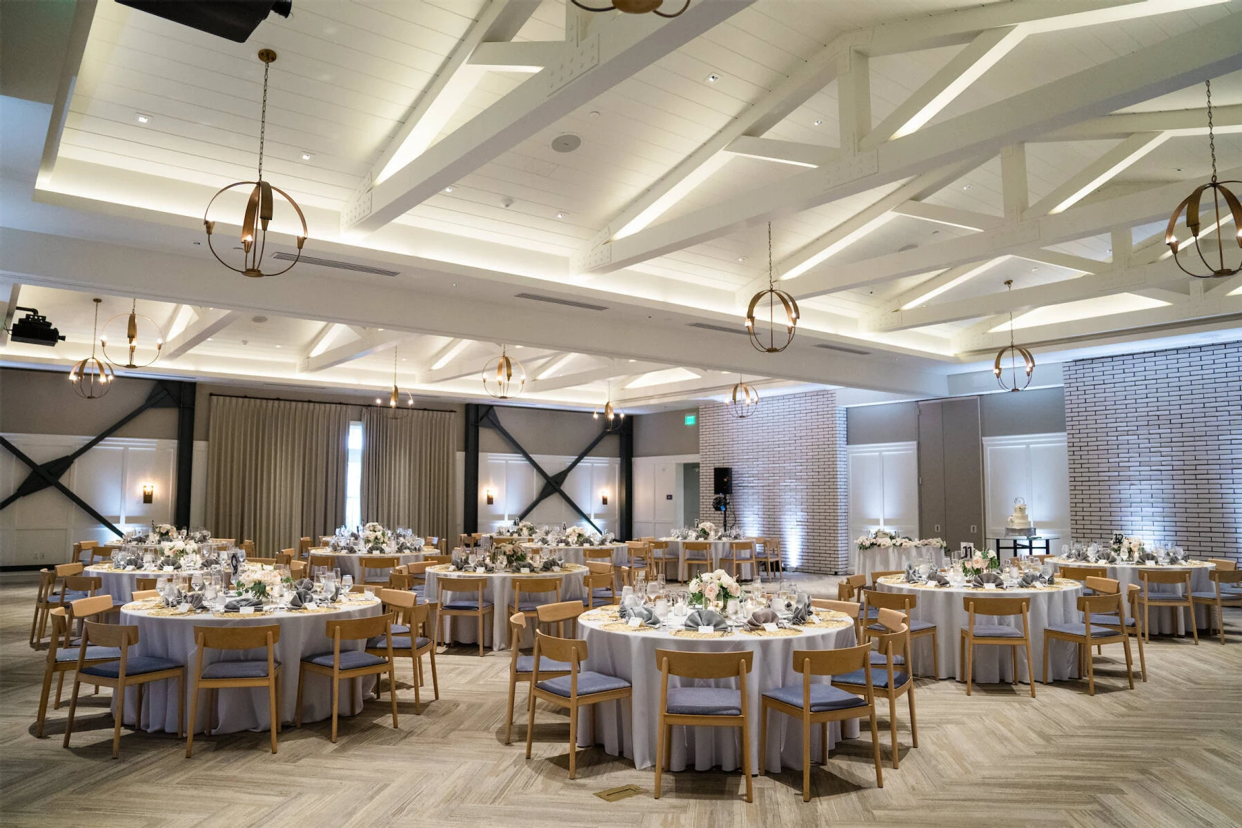 Marriott Weddings: An indoor reception setup with several round tables and hanging light fixtures at a hotel in Newport Beach California.