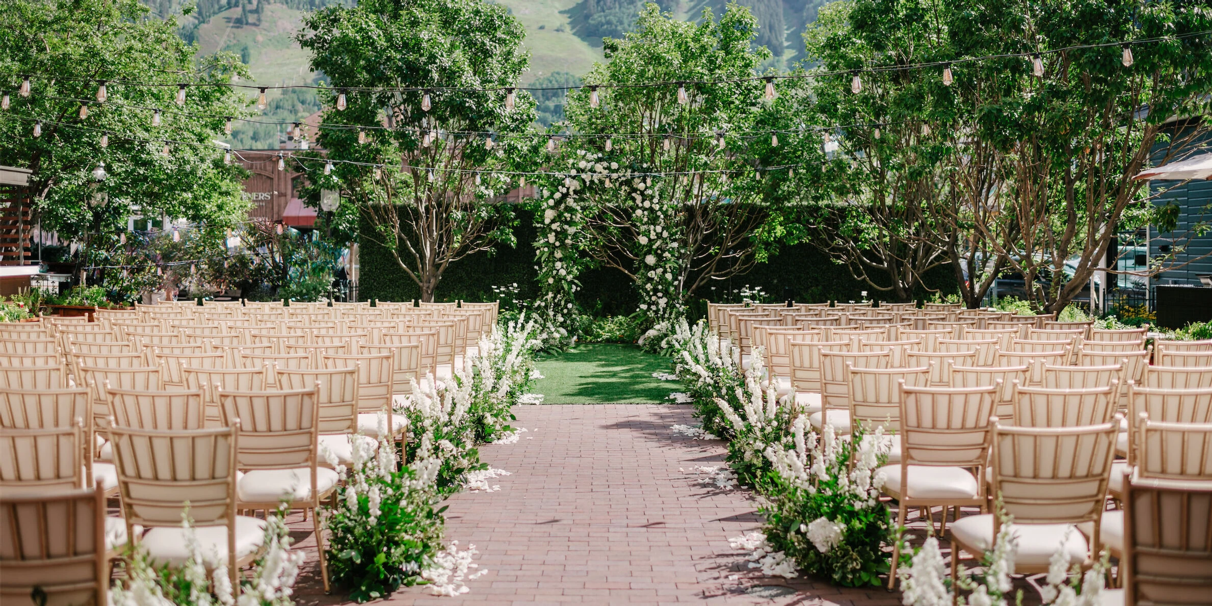 Mountain wedding details: The courtyard of Hotel Jerome, set up for a green-and-white wedding ceremony with views of the mountains in the distance.