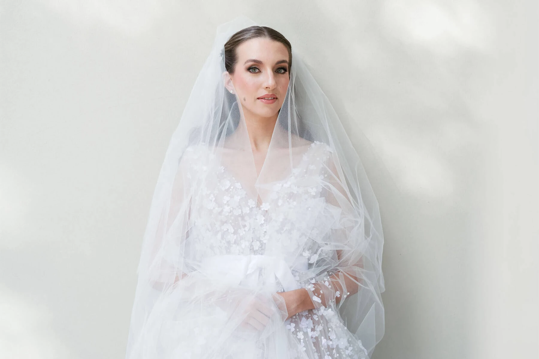 A bridal portrait in front of a plain white wall of a museum.